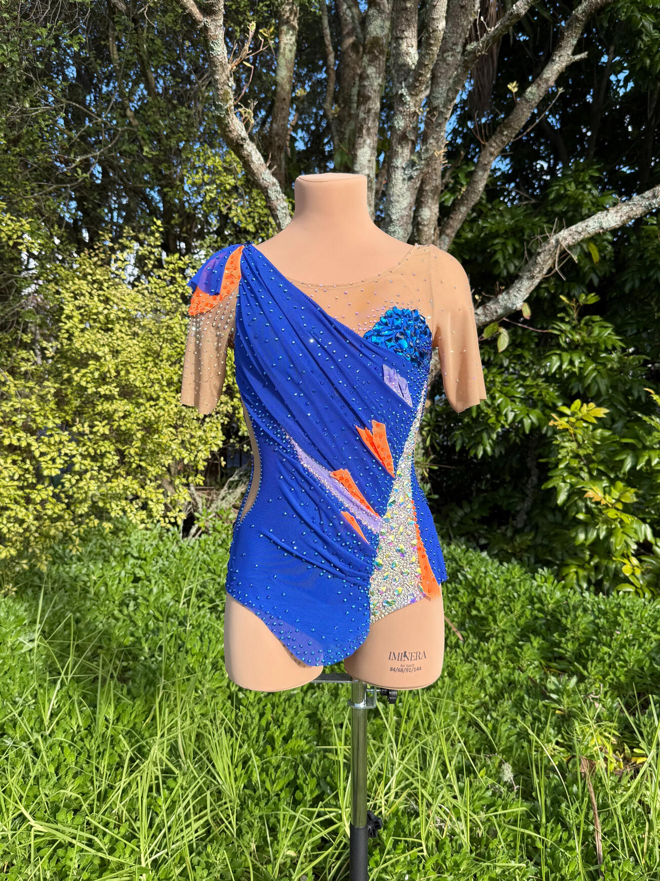 Rhythmic Gymnastics Leotard Royal blue rhythmic gymnastics leotard with lilac and hot orange accents. Heavily rhinestoned with almost 100 hand-sewn diamantés. Draped by hand to shape the body beautifully.